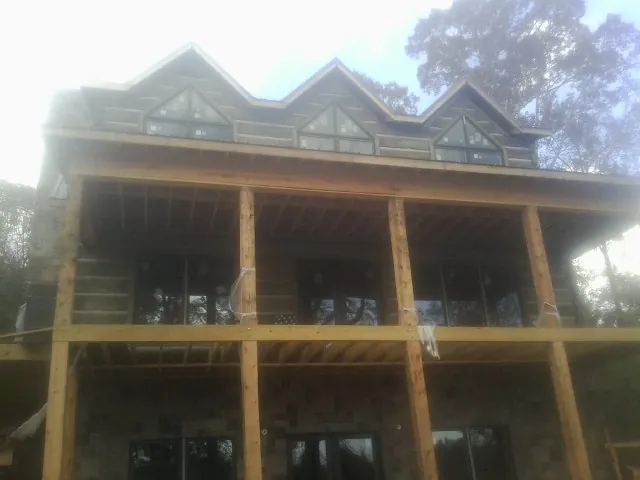 Dormers and porch framing on a large log home under construction — Roof Coating work by our crew in Hoodsport