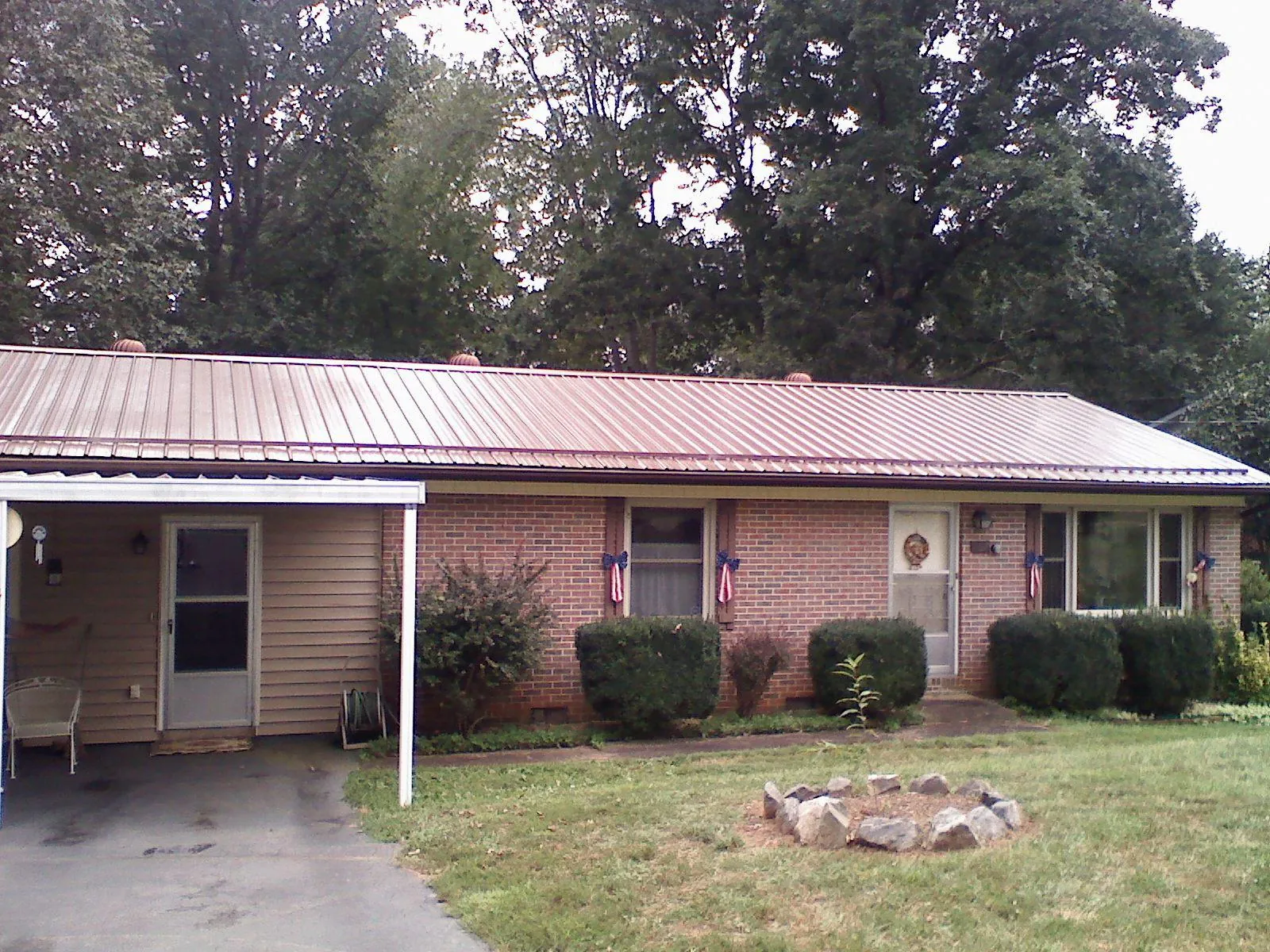 Bronze metal roof and carport on a brick ranch home — Roof Repair work by our crew in Hoodsport